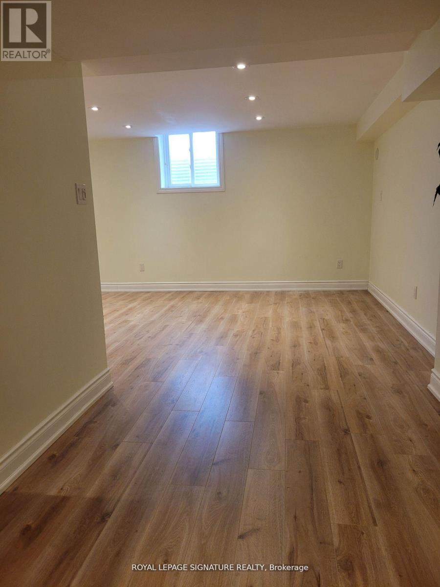 A room with wooden flooring and a window.