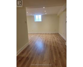 A room with wooden flooring and a window.