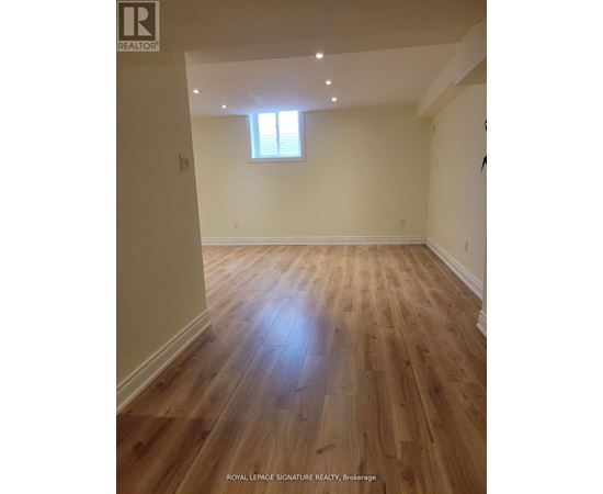 A room with wooden flooring and a window.