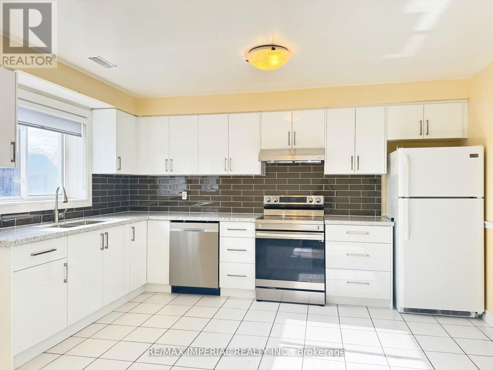 A kitchen with white cabinets and appliances.