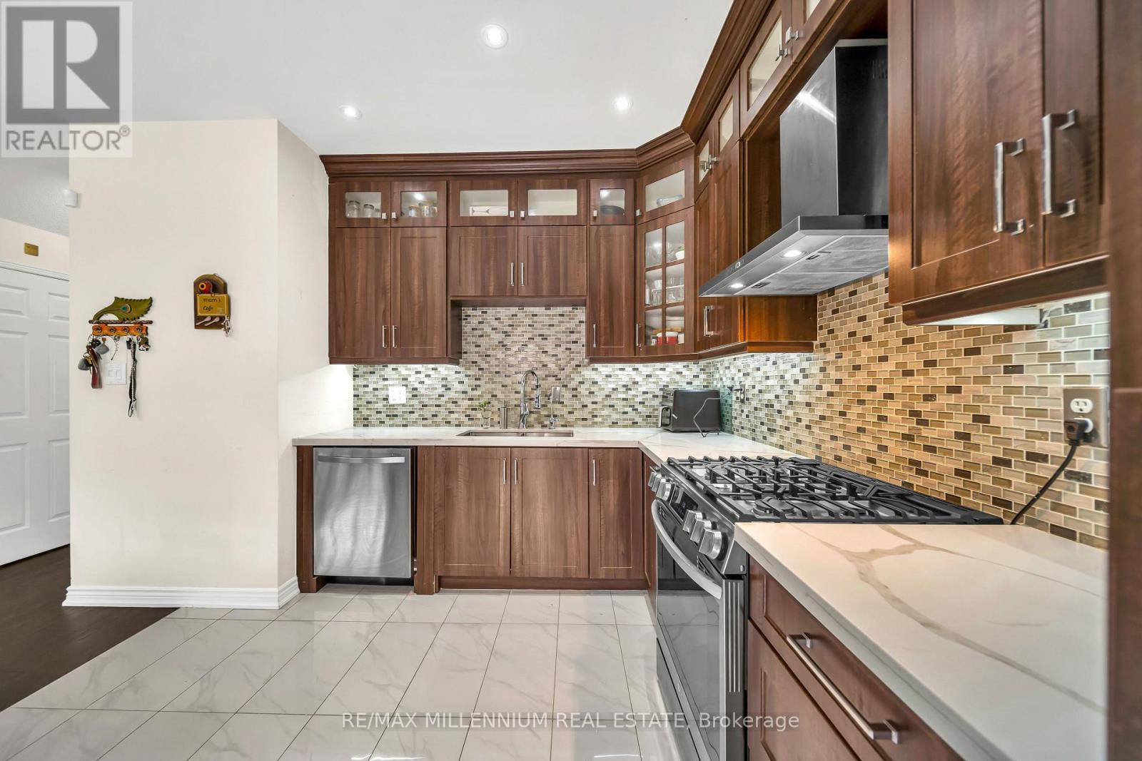 A kitchen with wooden cabinets and a tiled backsplash.