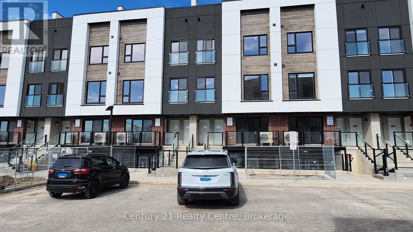 A black car is parked in front of a Century 21 Realty Centre.