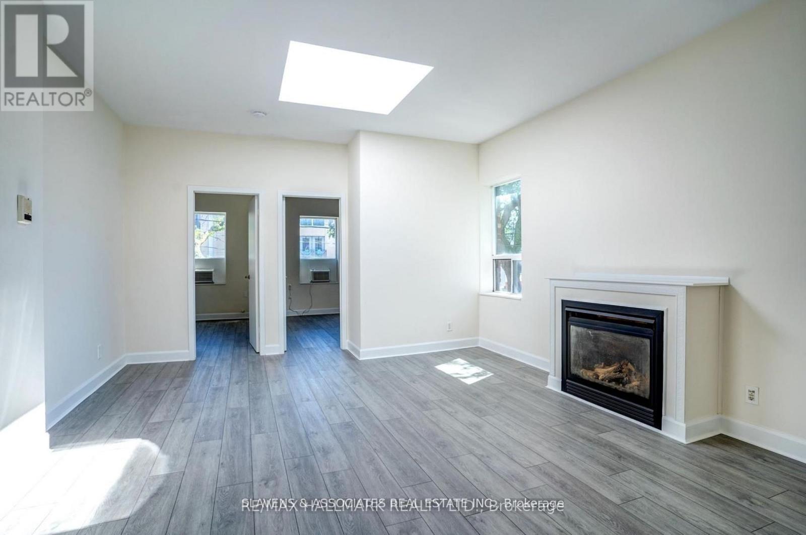 A spacious living room with a fireplace and hardwood floors.