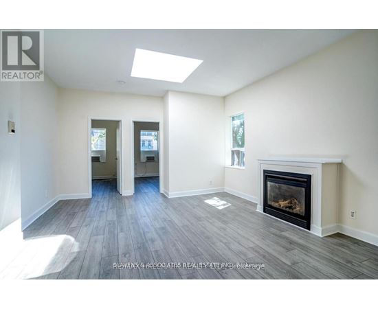 A spacious living room with a fireplace and hardwood floors.