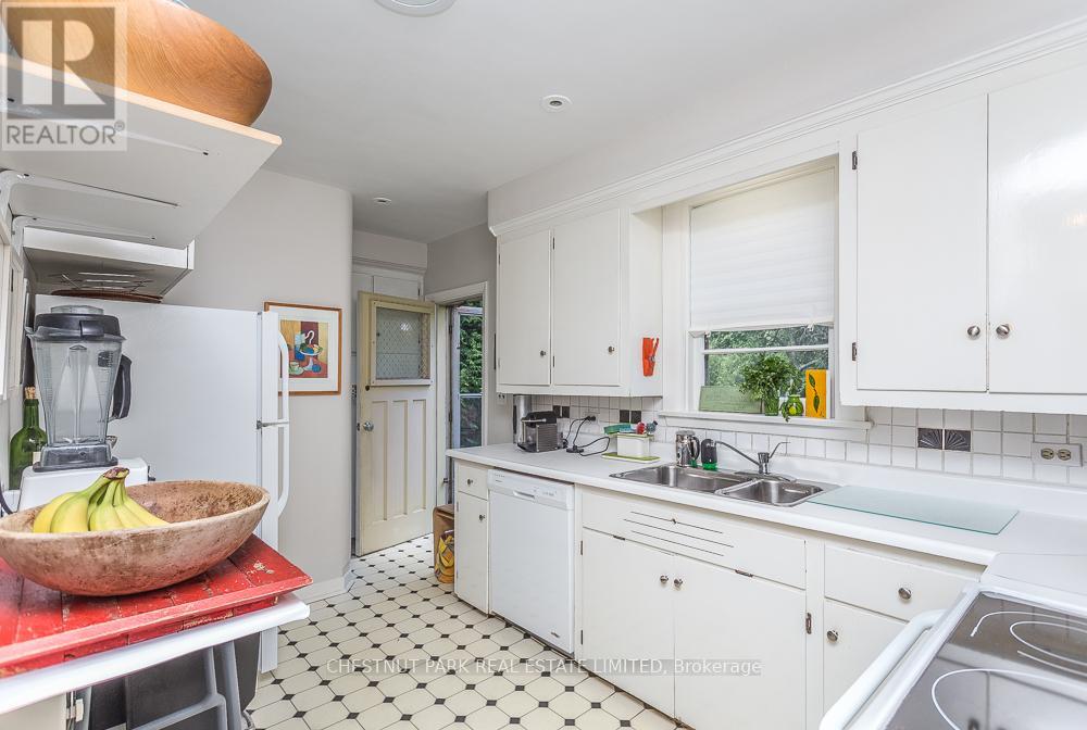 A kitchen with white cabinets and a black and white checkered floor.