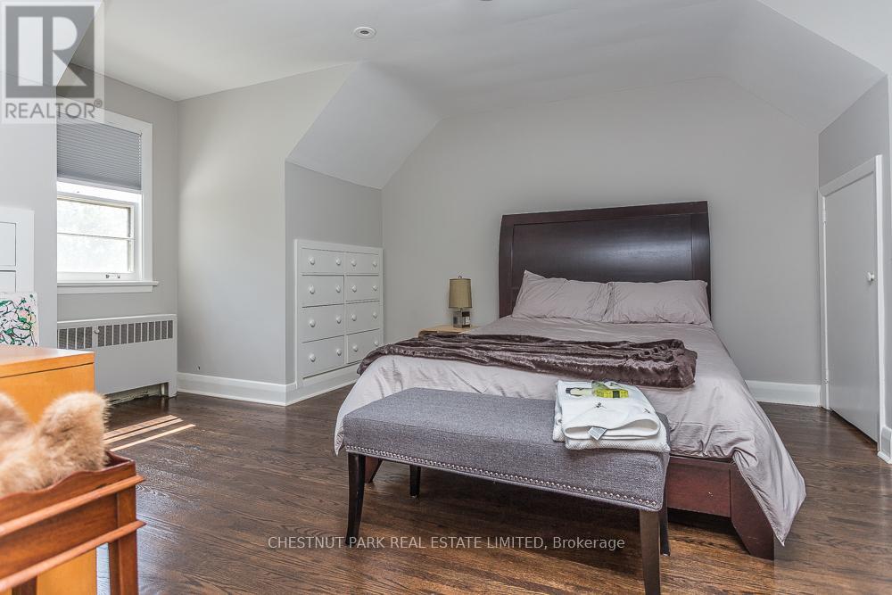A bedroom with a bed, nightstand, and a window.