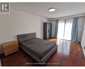 A bedroom with a bed, nightstand, and wardrobe.