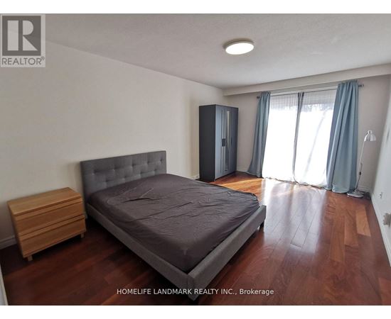 A bedroom with a bed, nightstand, and wardrobe.