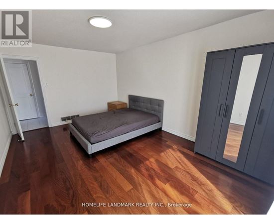 A bedroom with a bed, wardrobe and a wooden floor.