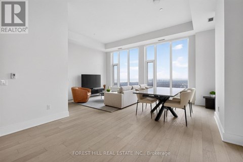 A living room with a table and chairs and a television.