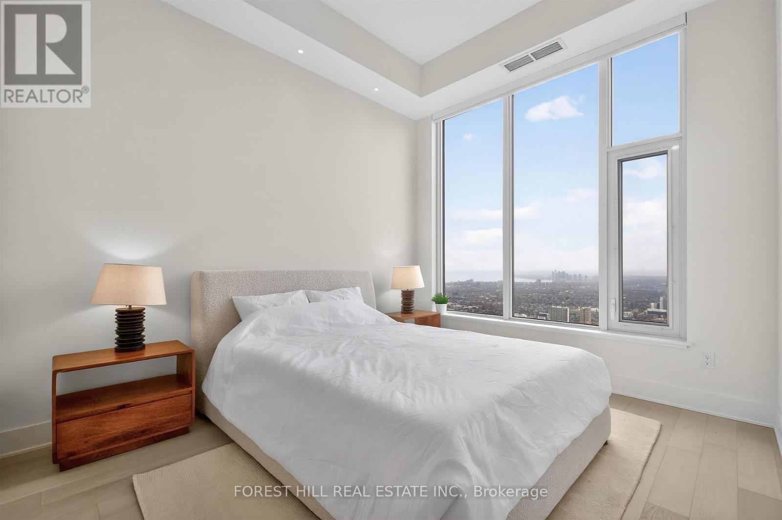 A bedroom with a large bed and a view of the city.