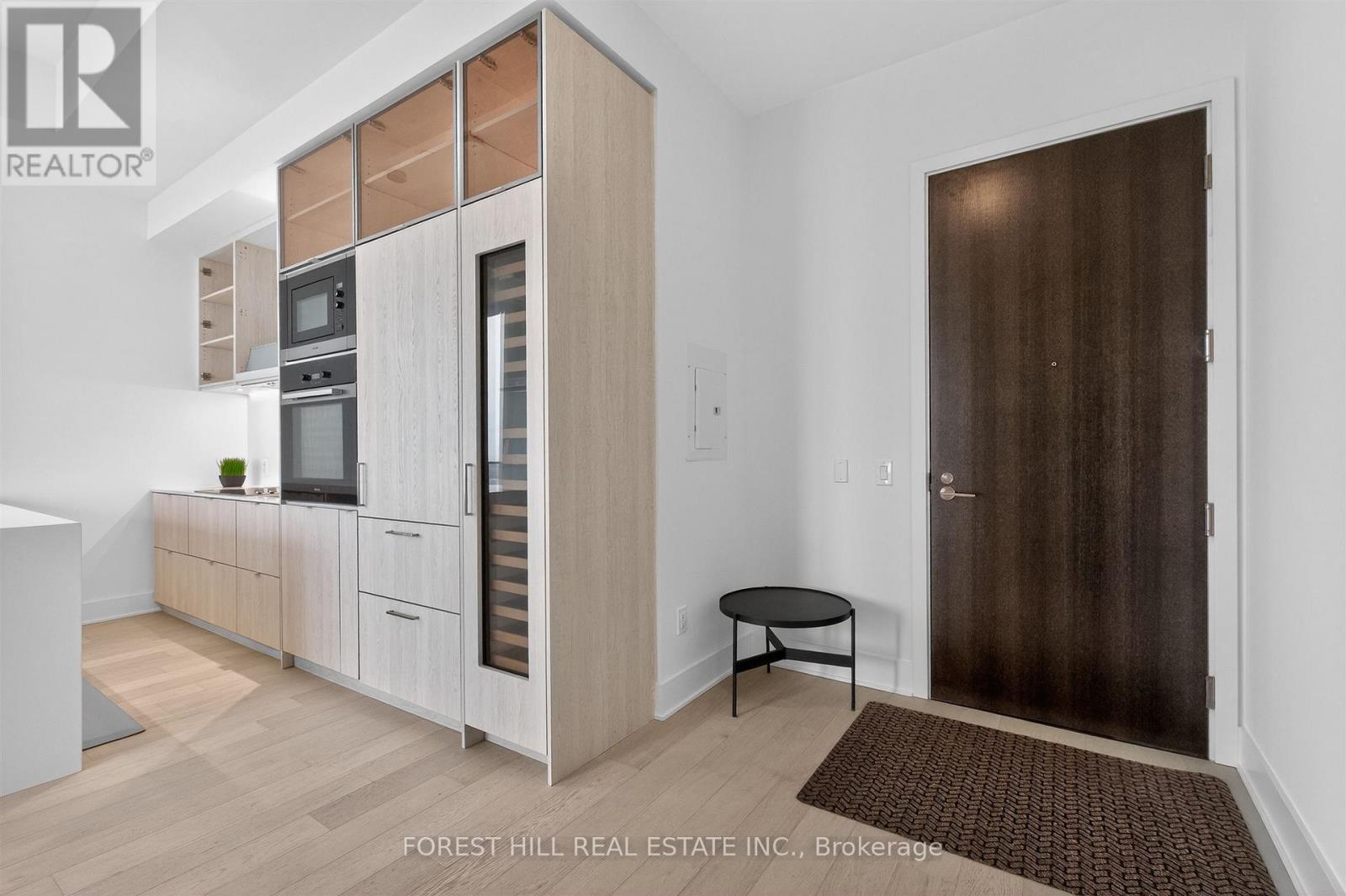 A modern kitchen with a refrigerator and cabinets.