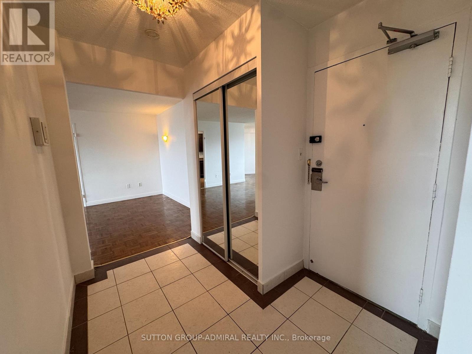 A hallway with a sliding door and a chandelier.