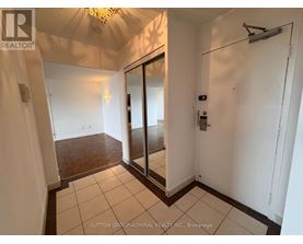 A hallway with a sliding door and a chandelier.
