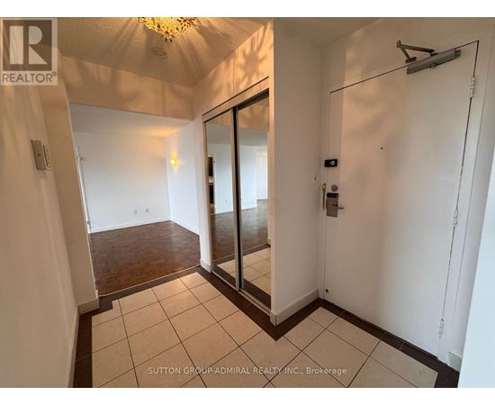 A hallway with a sliding door and a chandelier.