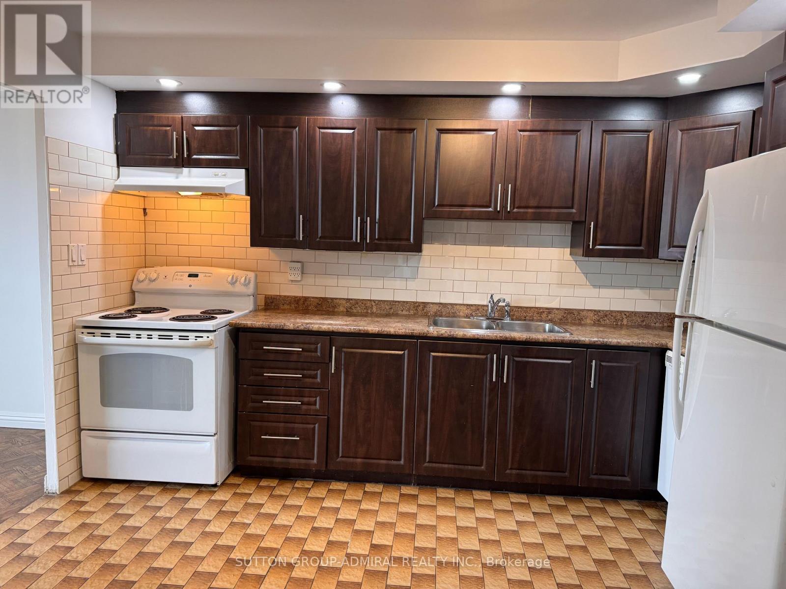 A kitchen with brown cabinets and a white stove.