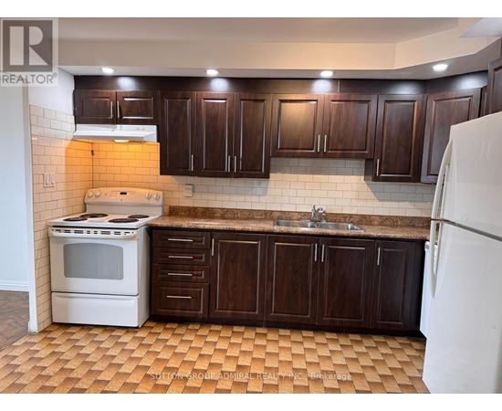 A kitchen with brown cabinets and a white stove.