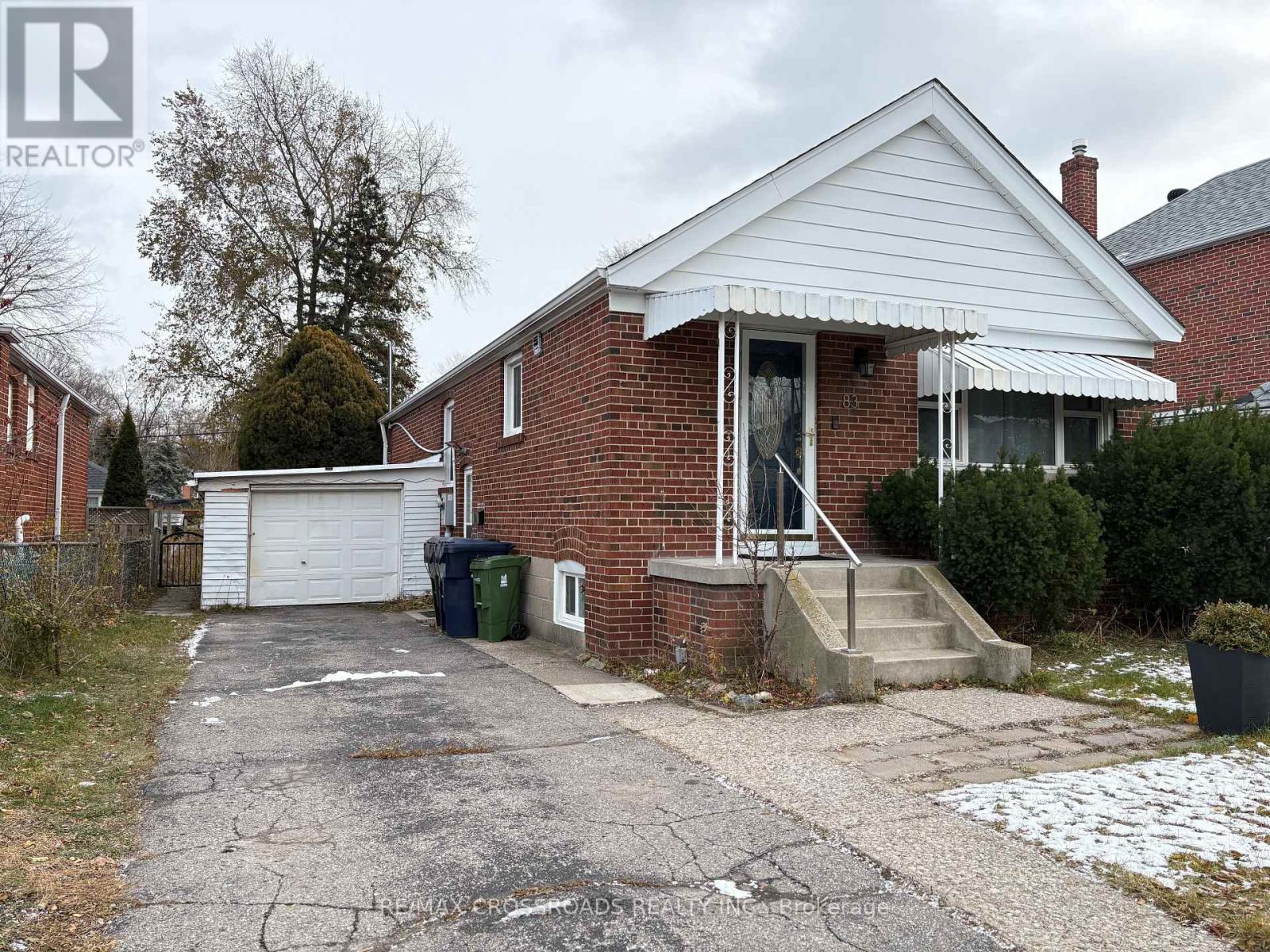 A house with a white garage door and a brick exterior.