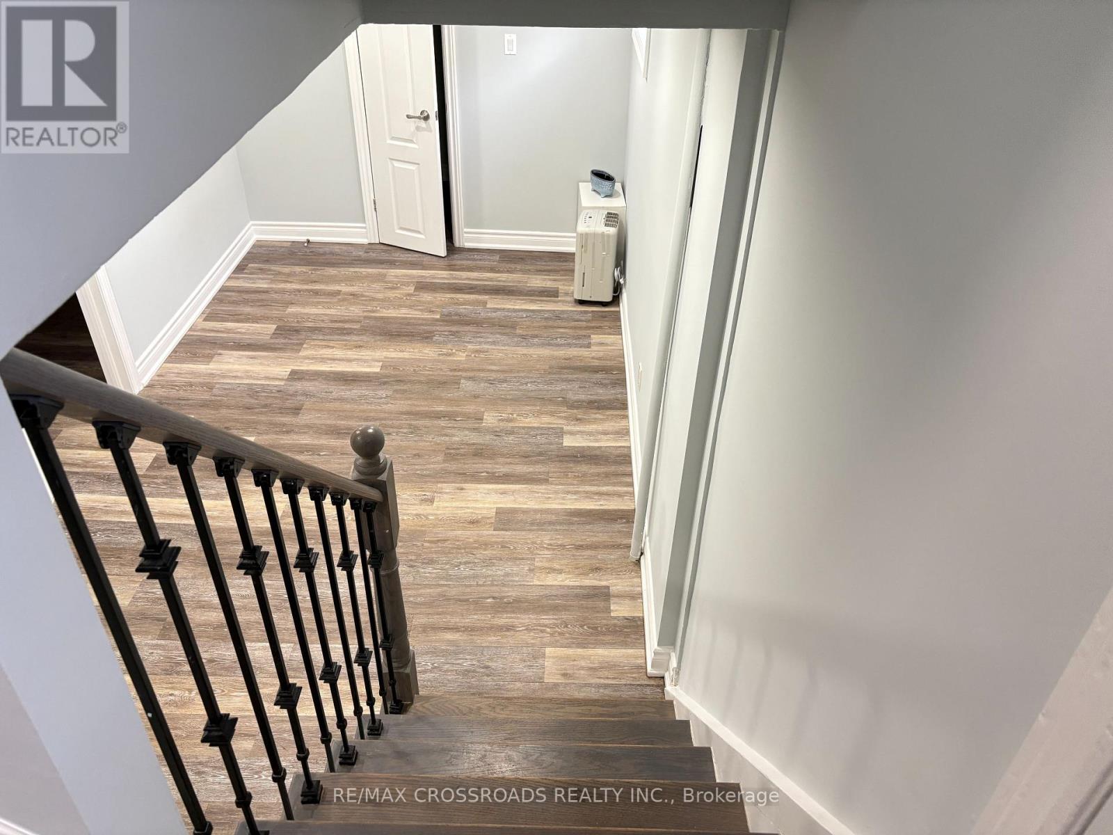 A staircase with a wooden floor and a metal railing.