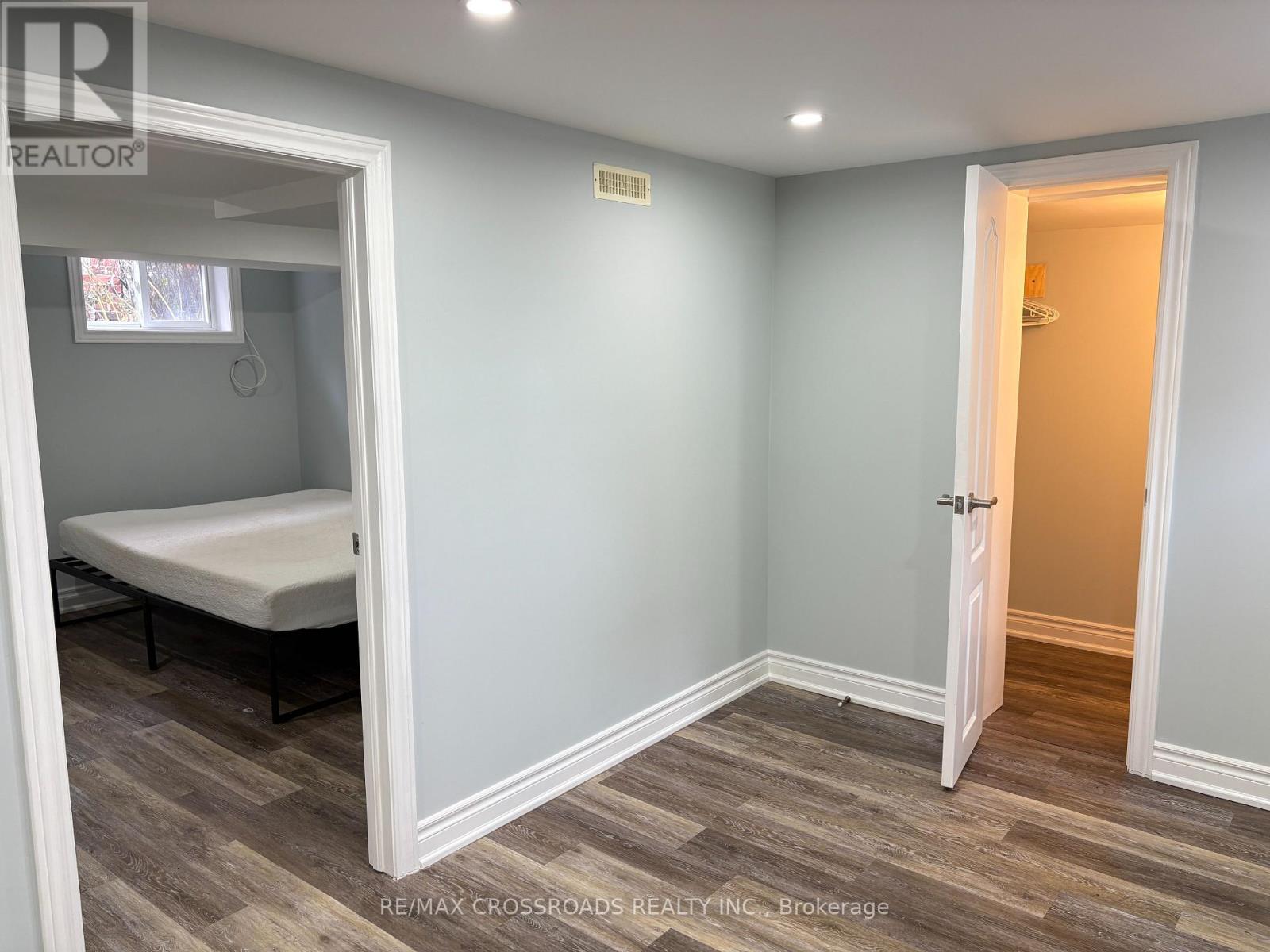 A bedroom with a bed and a wooden floor.