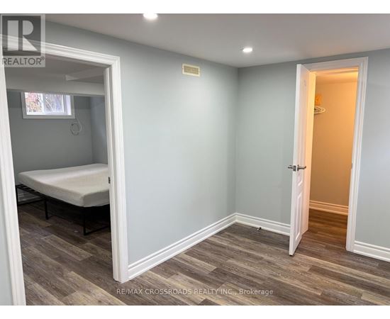 A bedroom with a bed and a wooden floor.