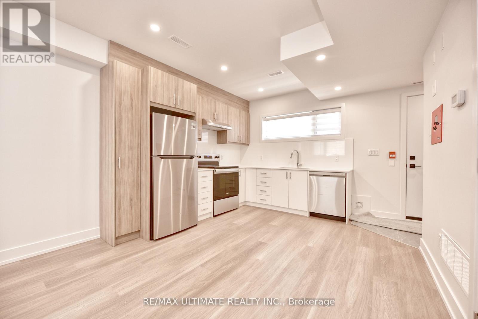 A kitchen with a refrigerator, dishwasher, and oven.