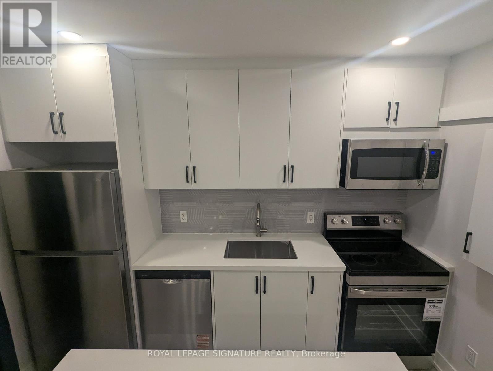 A kitchen with white cabinets and stainless steel appliances.