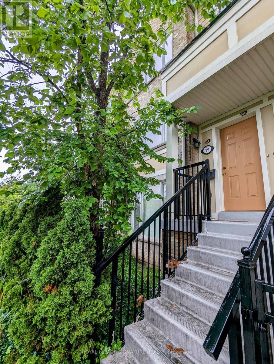 A brown door is on the right side of a staircase with a black railing.