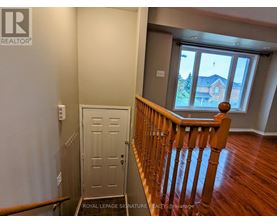 A room with a wooden staircase leading to a door.