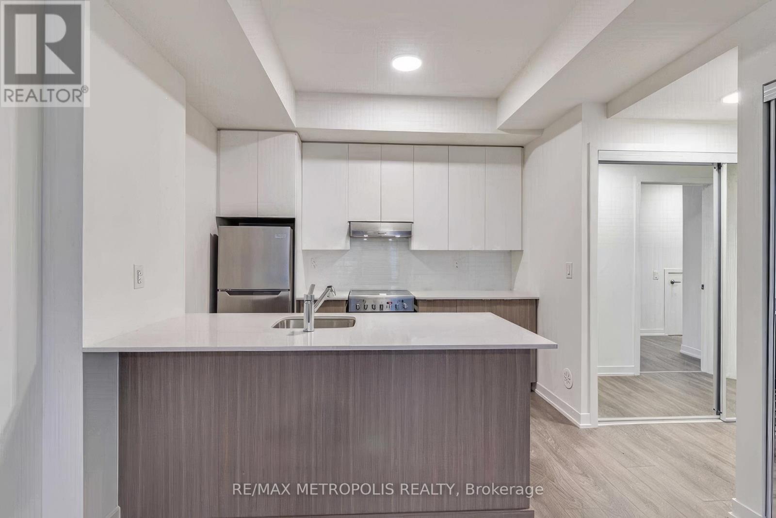 A modern kitchen with a sink and a refrigerator.