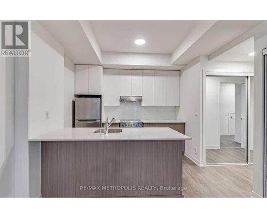 A modern kitchen with a sink and a refrigerator.