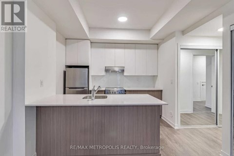 A modern kitchen with a sink and a refrigerator.
