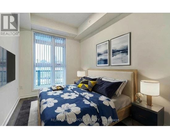 A bedroom with a bed, nightstand, and two pictures on the wall.