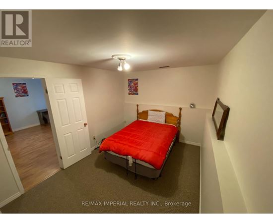 A bedroom with a red bed and a white door.