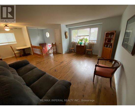 A living room with a grey couch and wooden floors.