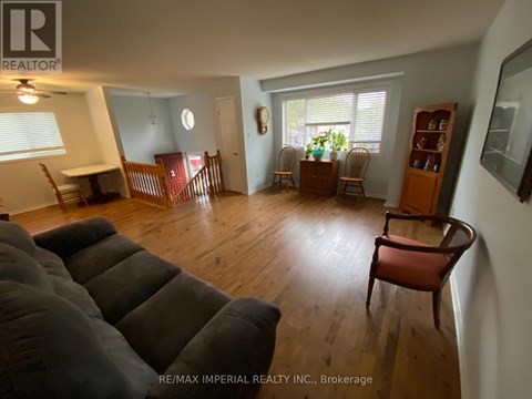A living room with a grey couch and wooden floors.