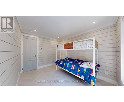 A bedroom with a bed and a small shelf above it.