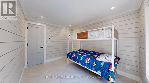 A bedroom with a bed and a small shelf above it.