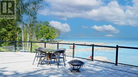 A table and chairs are set up on a patio overlooking a pool.
