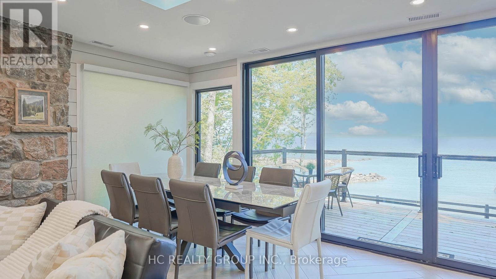 A dining room with a table set for six and a view of the water.