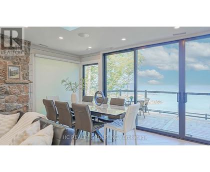 A dining room with a table set for six and a view of the water.