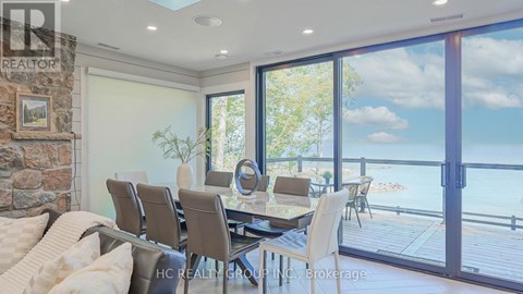 A dining room with a table set for six and a view of the water.