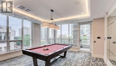 A pool table in a room with a view of the city.