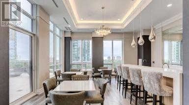 A modern dining room with a long table and chairs.