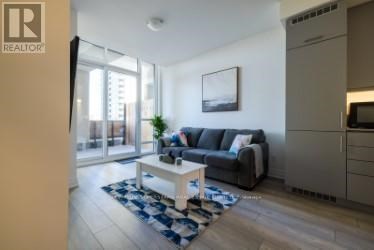 A living room with a grey couch and a coffee table.
