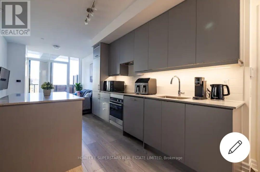 A modern kitchen with a large island and stainless steel appliances.