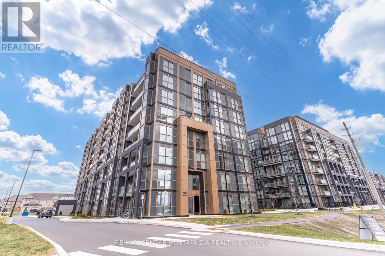 A modern multi-story building with a glass facade is under construction.