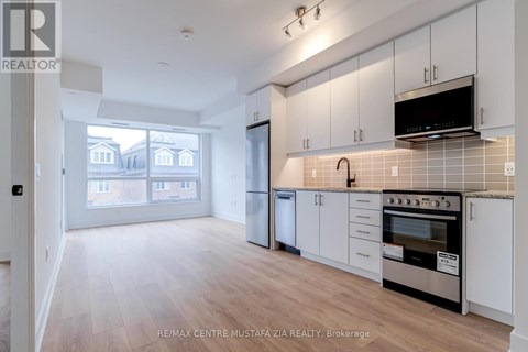 A kitchen with white cabinets and a black stove top oven.