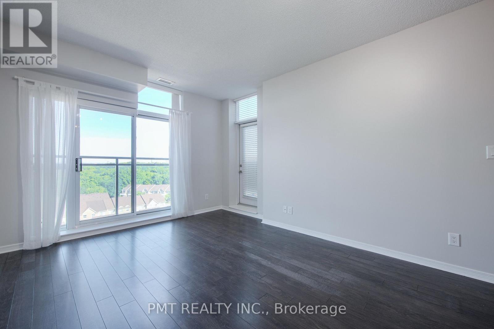 A spacious room with a view of the outside through the sliding glass door.