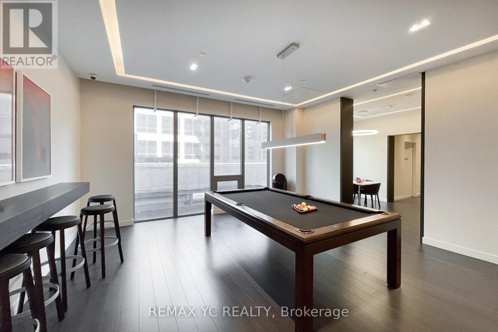 A pool table in a room with a bar area.